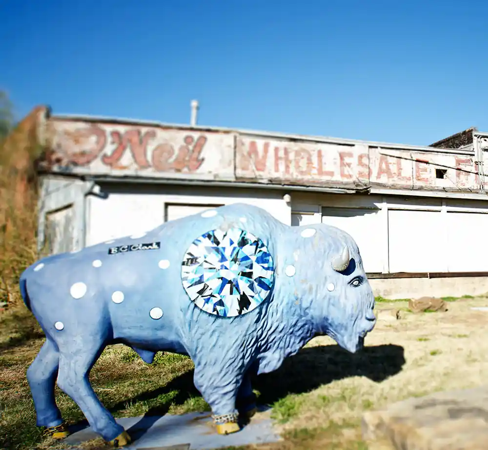 Blue buffalo statue in front of an old building
